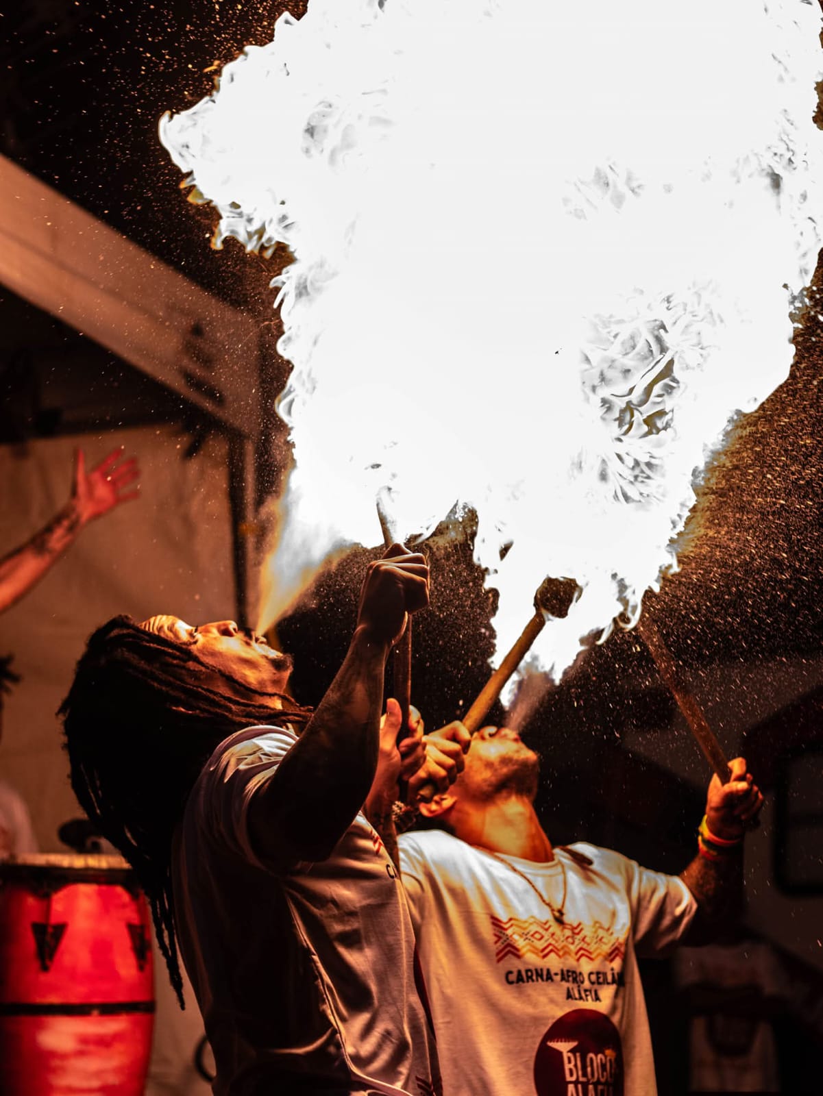Apresentação cultural do Bloco Aláfia com performance pirotécnica e tambores ao ar livre