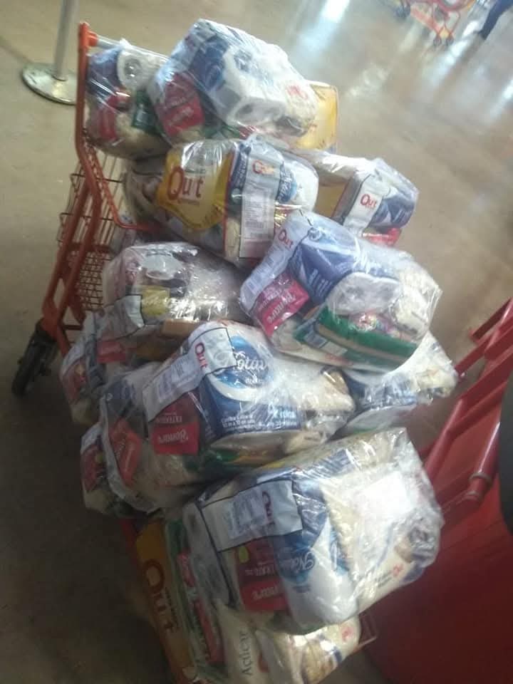 Carrinhos de supermercado repletos de cestas básicas de alimentos prontas para distribuição à comunidade pelo projeto